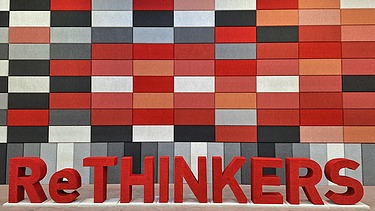 Dieses Bild zeigt eine Wand mit beschichteten Akustikplatten, davor das Wort Rethinkers aus Buchstaben aus Naporo Plattenn