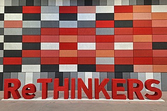 Rethinkers Dieses Bild zeigt eine Wand mit beschichteten Akustikplatten, davor das Wort Rethinkers aus Buchstaben aus Naporo Plattenn