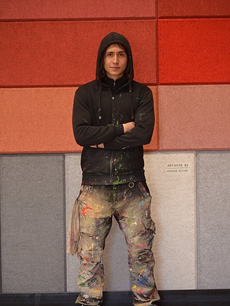 Dieses Bild zeigt Oliver Nowak vor der fertigen Wand in Arbeitskleidung
