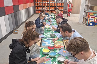 Dieses Bild zeigt wie die Besucher:innen gerade ihre Akustikplatten bemalen